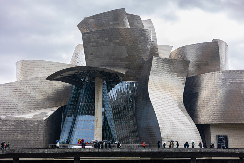 A large silver, metalic, building with lots of curved surfaces.