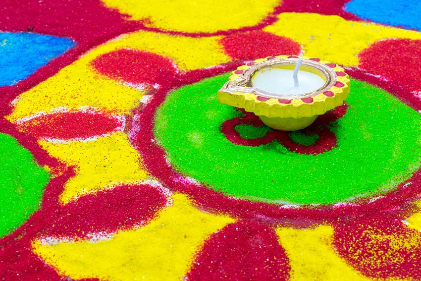 Clay oil lamp on a colourful rangoli pattern