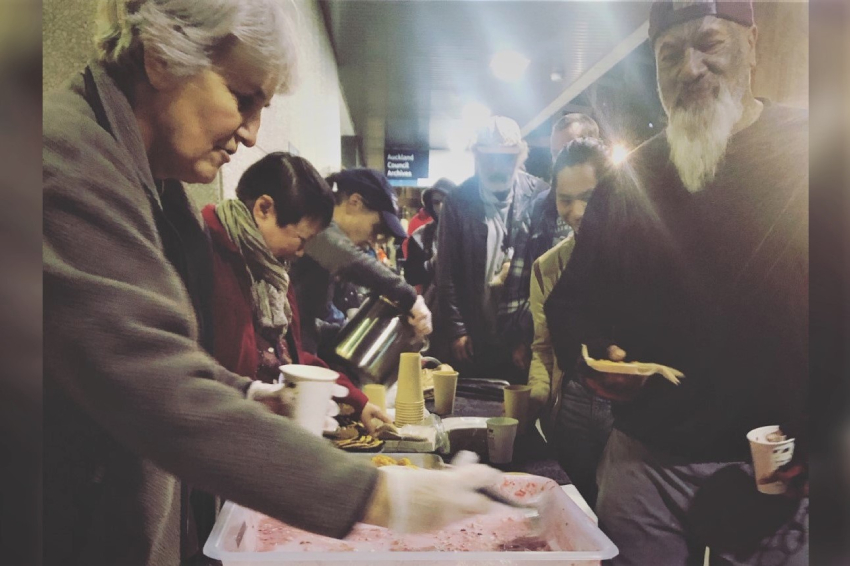 A Sunday Blessings volunteer serves panna cotta to customers.