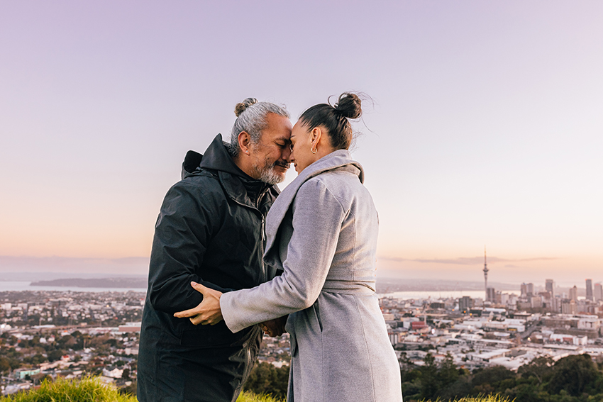 Man and woman hongi with Auckland City in background.