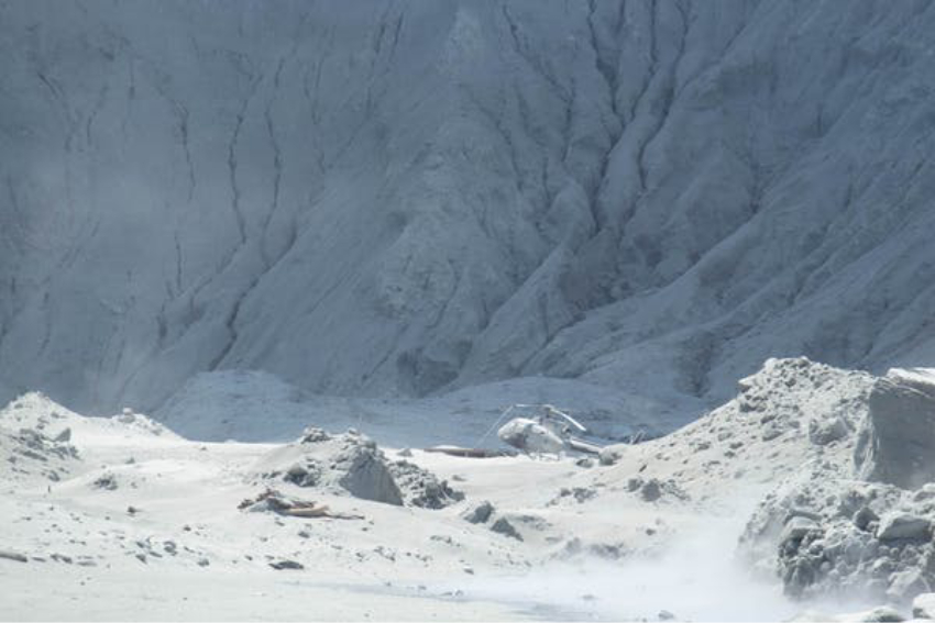 A helicopter on Whakaari/White Island covered in ash after the eruption.