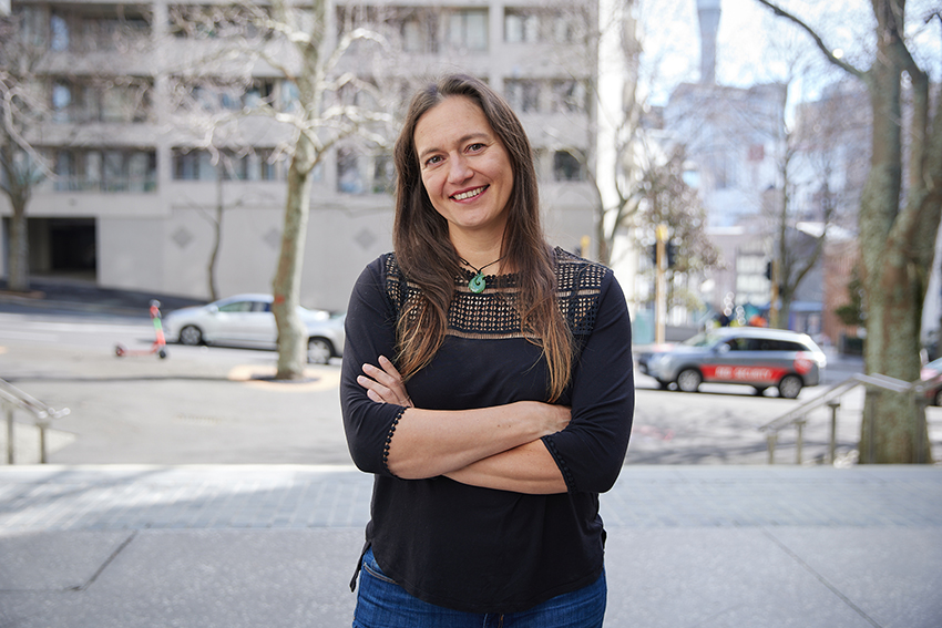 Dr Antje Deckert standing arms folded and smiling at the camera.