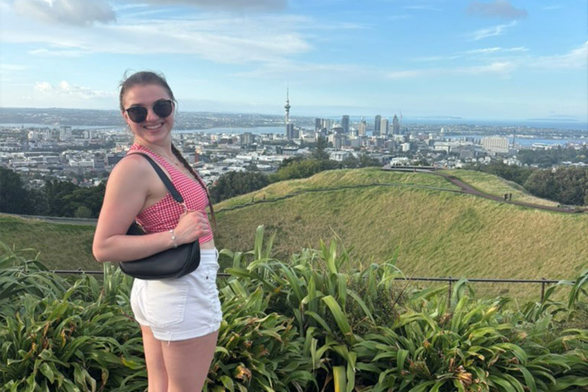 Sydney posing on Mount Eden during mid-day, Auckland city, SkyTower and marina are in the background