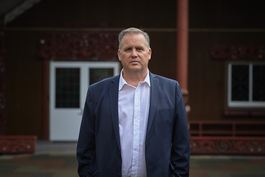 Paul Moon standing in front of the wharenui at AUT