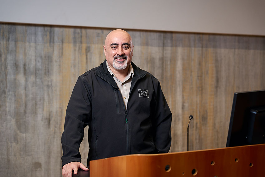 AUT Professor standing in lecture theatre .