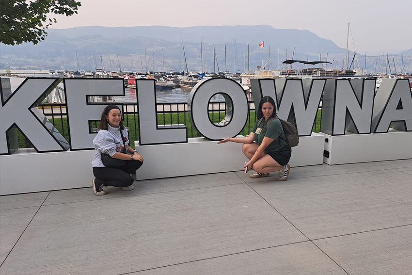 Remy posing in front of a sign which says KEWLONA