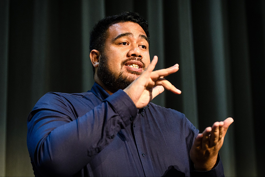 A professional photo of AUT alum Alan Wendt practicing NZSL-interpreting, dressed in a blue shirt.