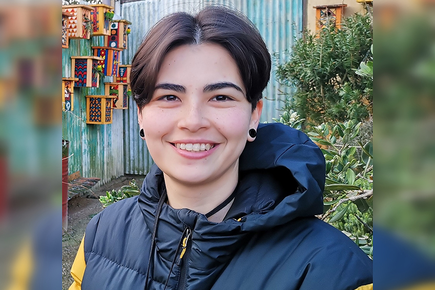 A head and shoulders photo of Zoe King in a black and yellow puffer jacket.
