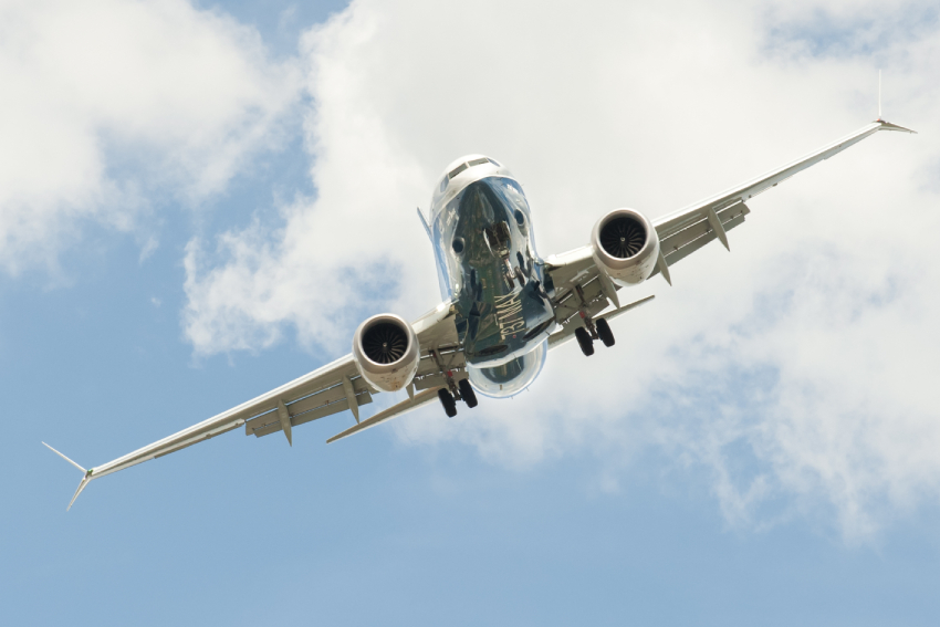 A Boeing 737 MAX in the air, seen from the front.