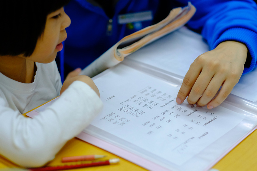 A child being studying with a parent.