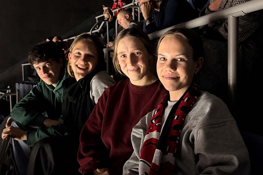 Friends posing for a photo in a dimly lit room