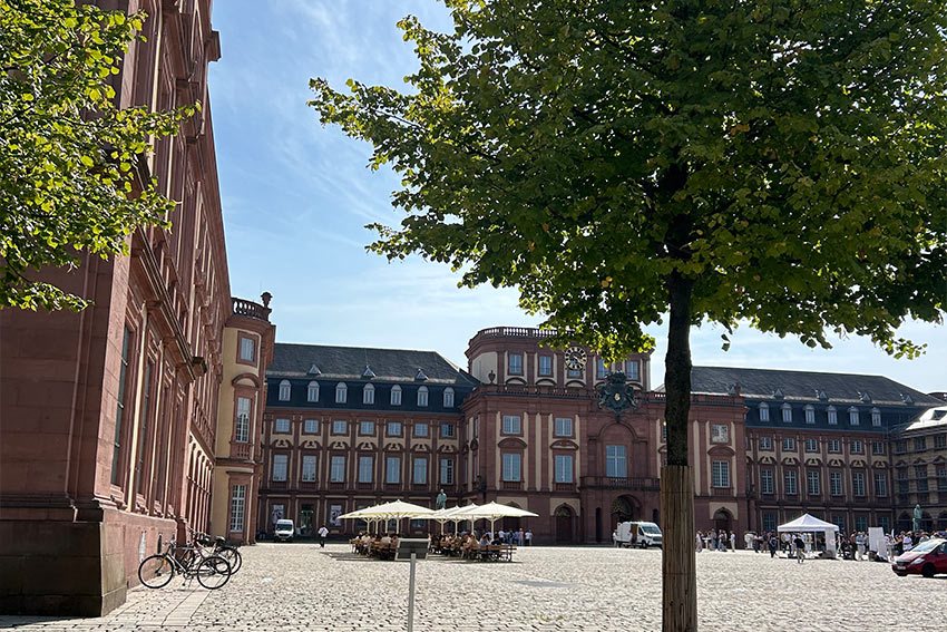 A historic building with a market square in the day time