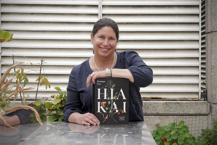 Tracy Berno holding the book Hiakai and smiling.