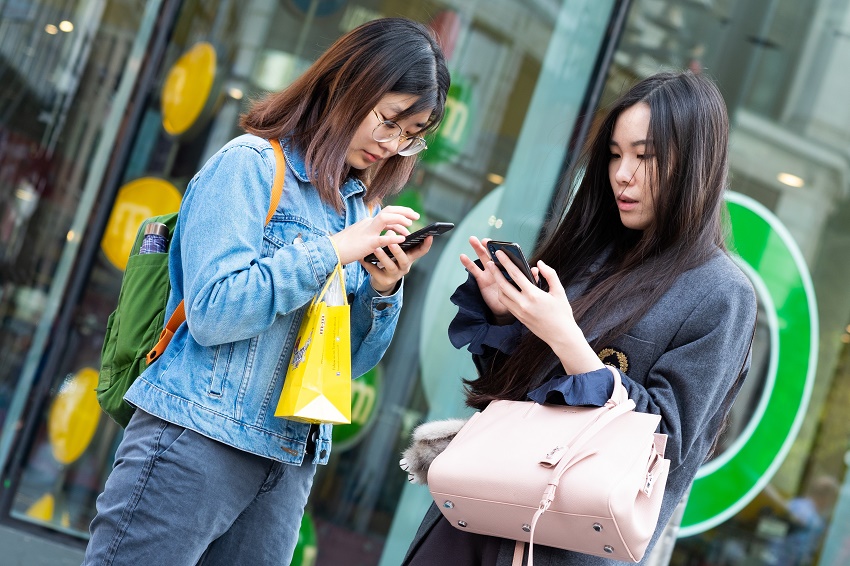 Two people using their cellphones