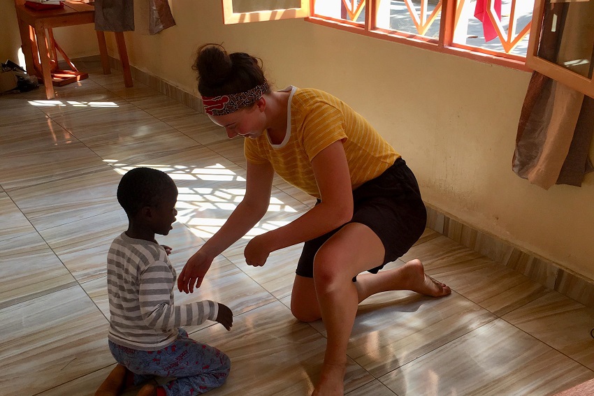Eloise Wilson helping a child in Burundi