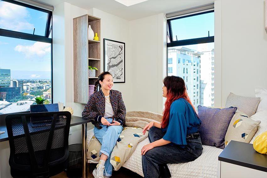 2 students talking in studio accommodation room