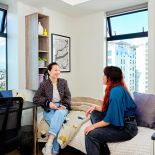 2 students talking in studio accommodation room