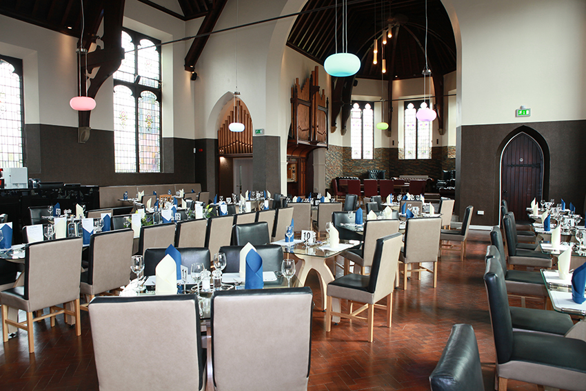 Chairs and tables laid out for fine dining in a The Clink restaurant.