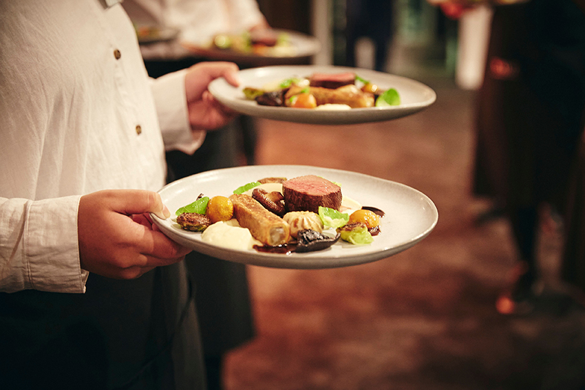 Plates of delicous-looking food being served.