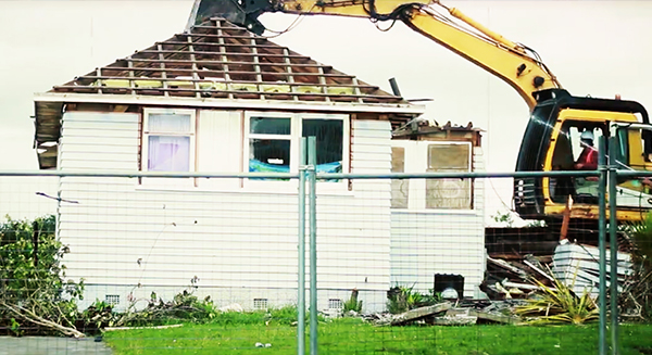 A digger breaking up a residential home