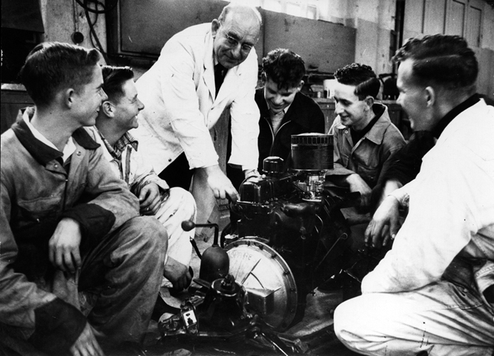 1957 — Staff and students of Seddon Memorial Technical College examine the features of a new internal combustion engine, presented to them by the Auckland Garage Proprietors’ Association.