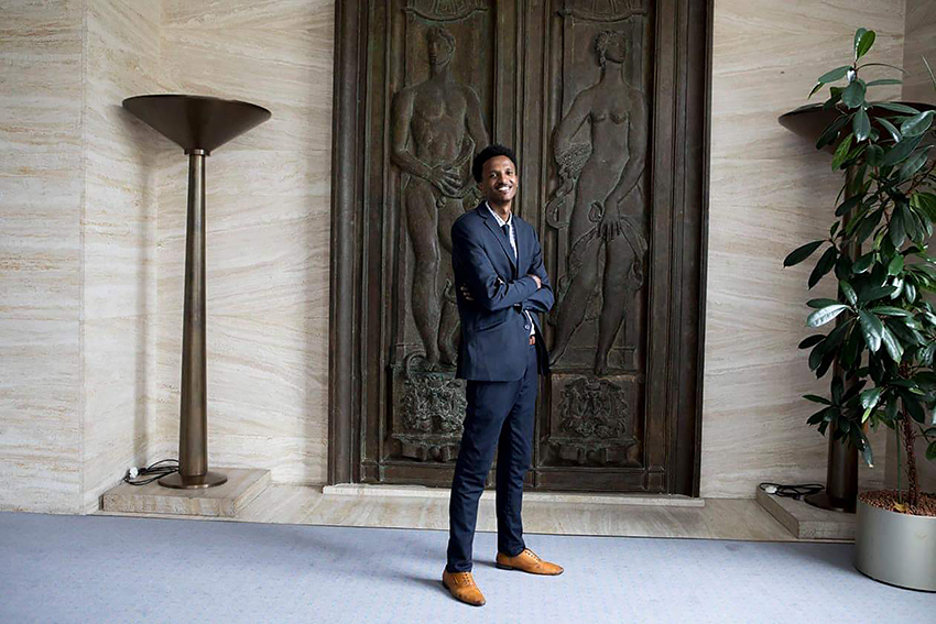 Guled Mire standing in front of large and ancient-looking doors in Africa.