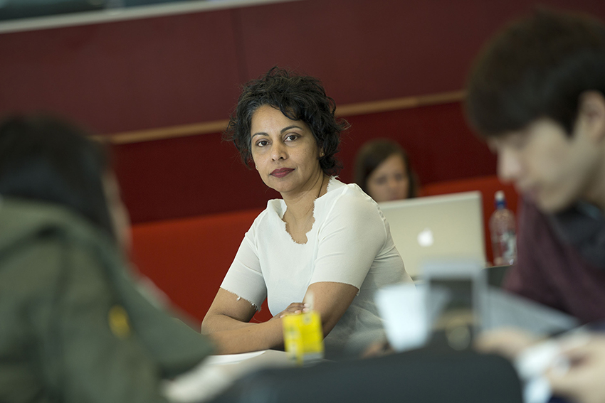 Professor Rhema Vaithianathan sitting arms crossed and looking at the camera.